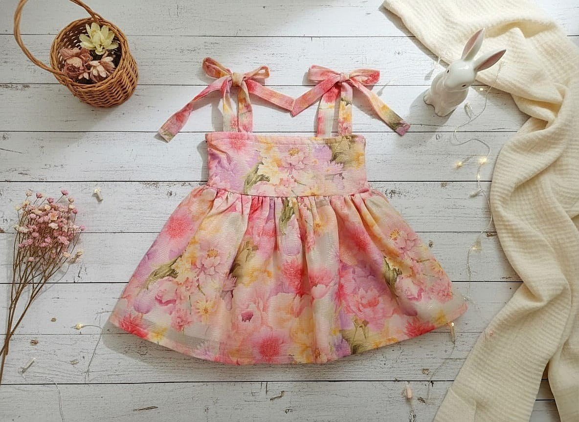 kids pink floral printed summer dress with tie-up straps and flowy silhouette in georgette fabric.