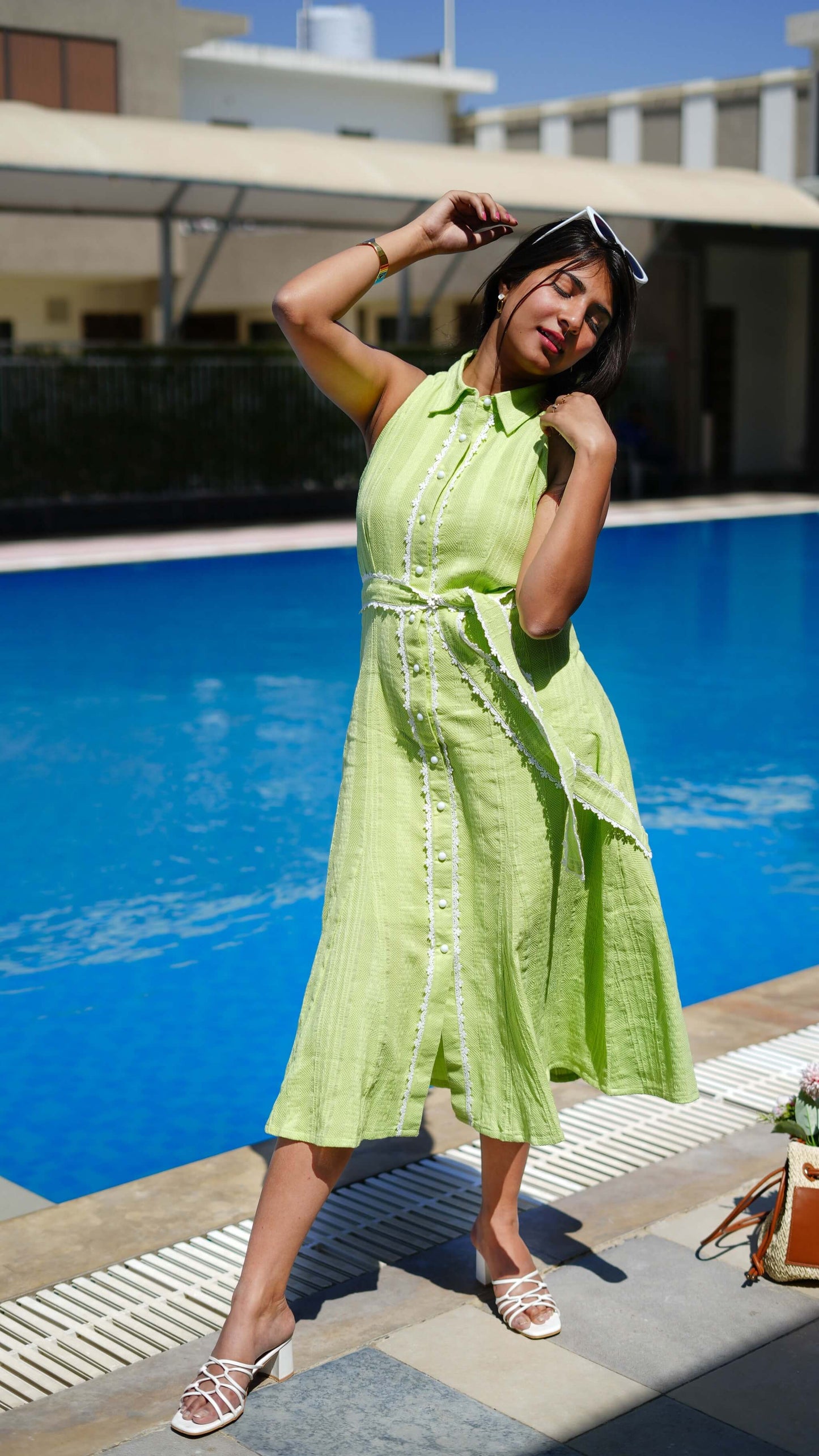 Fern MotherDress by soliesse, shirt dress midi lenght with belt & white lace edge detailing. she is standing pool side.