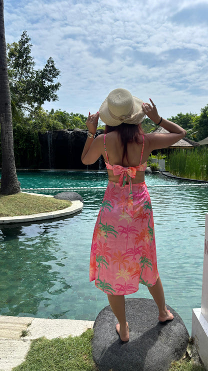 WOMEN IN SATIN TROPICLA PRINTED DRESS ...SHOWING BACK VIEW DETAILING, BOW WAIST CUT OUT. WEARING THIS DRESS ON HER VACATION POOL SIDE.